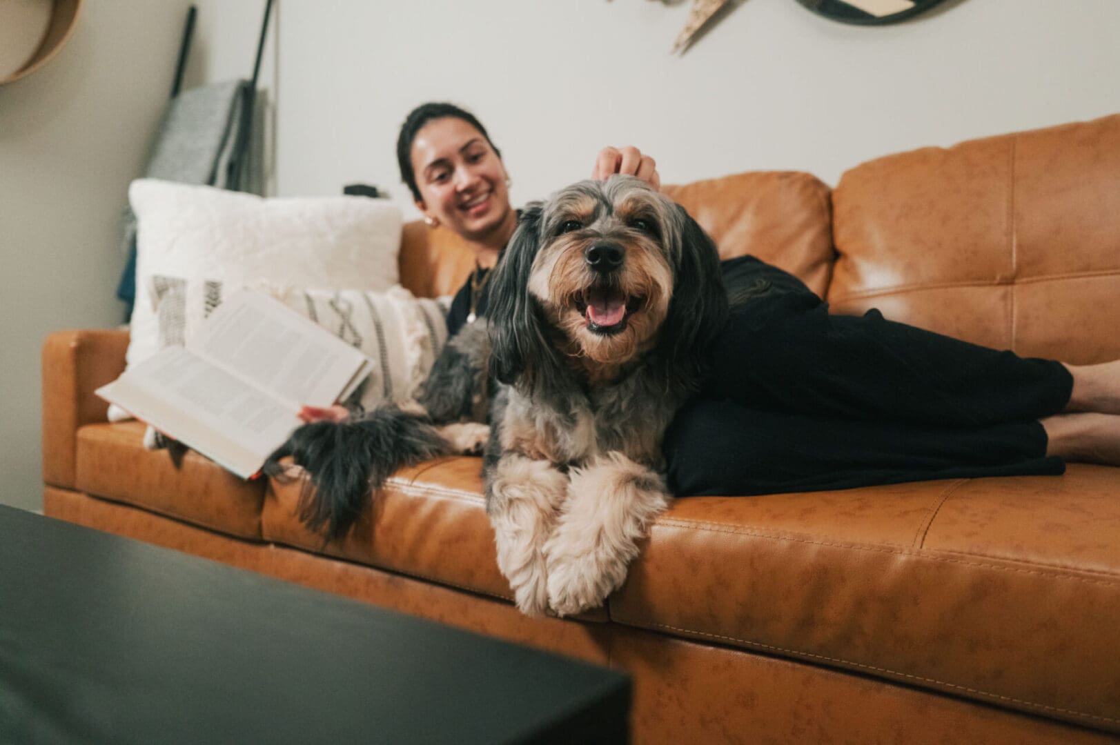 Woman relaxing on sofa with happy dog.