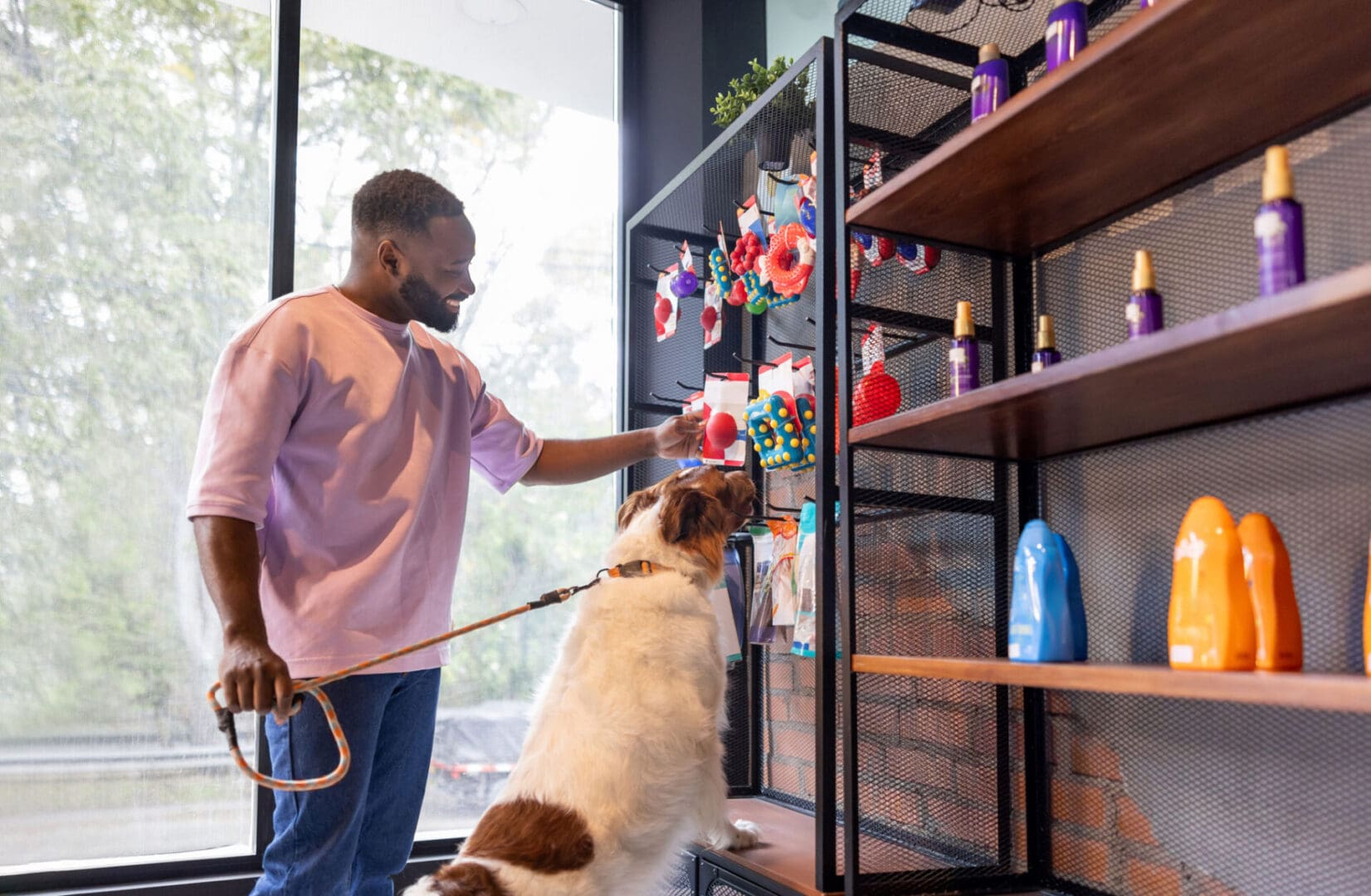Man shopping for dog toys with pet.